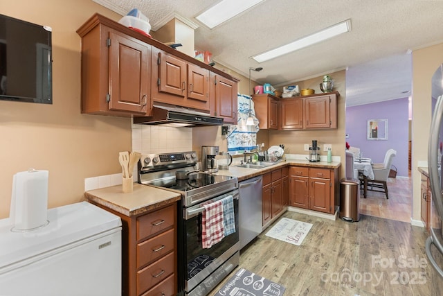 115 Red Fox Ct, Mount Holly, NC 28120 - kitchen with appliances with stainless steel finishes, under cabinet range hood, light wood-style floors, lofted ceiling, and light countertops