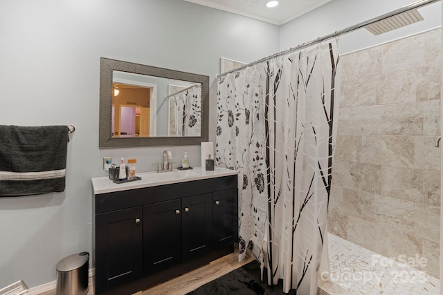 115 Red Fox Ct, Mount Holly, NC 28120 - bathroom featuring vanity, tiled shower, crown molding, and wood finished floors
