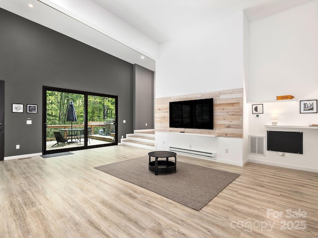 1761 Williamson Creek Rd, Pisgah Forest, NC 28768 - unfurnished living room with a towering ceiling, wood finished floors, baseboard heating, and recessed lighting