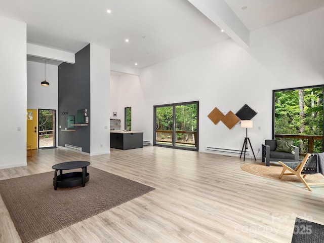 1761 Williamson Creek Rd, Pisgah Forest, NC 28768 - unfurnished living room featuring a high ceiling, plenty of natural light, wood finished floors, recessed lighting, and a baseboard radiator