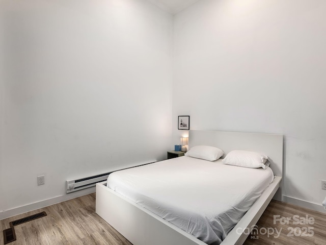 1761 Williamson Creek Rd, Pisgah Forest, NC 28768 - bedroom featuring a baseboard radiator and light wood finished floors