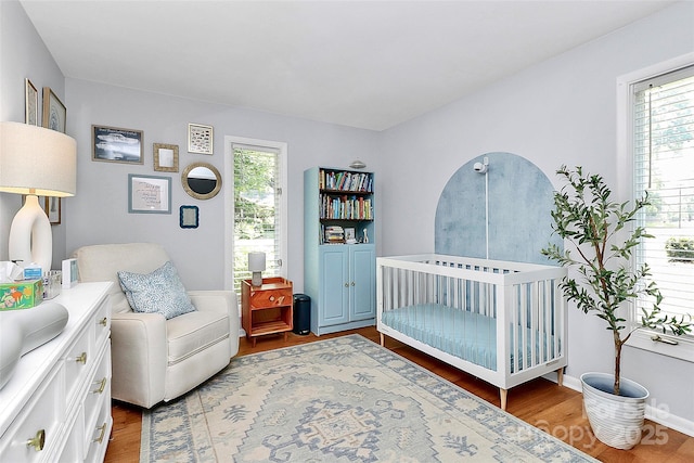 4906 Crooked Oak Ln, Charlotte, NC 28226 - bedroom featuring wood finished floors, a crib, and multiple windows