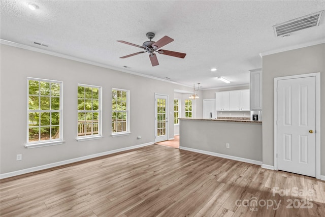 145 Summerbrook Ln, Mooresville, NC 28117 - unfurnished living room with ceiling fan, a textured ceiling, light wood-type flooring, ornamental molding, and a chandelier