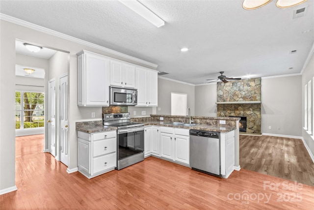 145 Summerbrook Ln, Mooresville, NC 28117 - kitchen featuring appliances with stainless steel finishes, light wood finished floors, ceiling fan, a peninsula, and white cabinetry