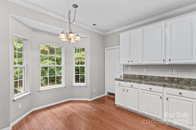 145 Summerbrook Ln, Mooresville, NC 28117 - kitchen featuring a chandelier, dark countertops, light wood-style floors, white cabinetry, and decorative light fixtures