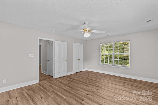 145 Summerbrook Ln, Mooresville, NC 28117 - unfurnished bedroom with wood finished floors, ceiling fan, and a textured ceiling