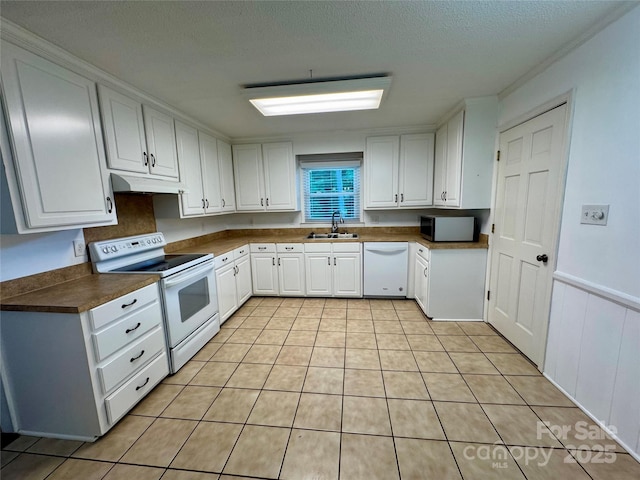 635 Windsor Pl NE, Concord, NC 28025 - kitchen featuring white appliances, under cabinet range hood, white cabinets, dark countertops, and light tile patterned floors
