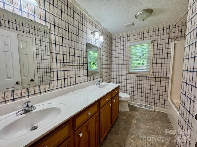 635 Windsor Pl NE, Concord, NC 28025 - full bathroom with a textured ceiling, double vanity, washtub / shower combination, tile patterned floors, and wallpapered walls