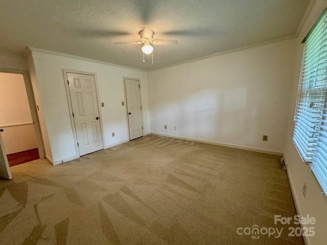 635 Windsor Pl NE, Concord, NC 28025 - unfurnished bedroom with carpet flooring, crown molding, a textured ceiling, multiple closets, and a ceiling fan