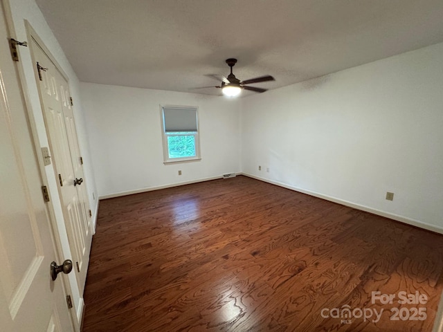 635 Windsor Pl NE, Concord, NC 28025 - unfurnished bedroom with dark wood-style flooring and ceiling fan