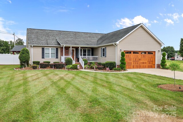 1974 Redwood Dr, Oakboro, NC 28129 - ranch-style home with a porch, an attached garage, driveway, and a shingled roof