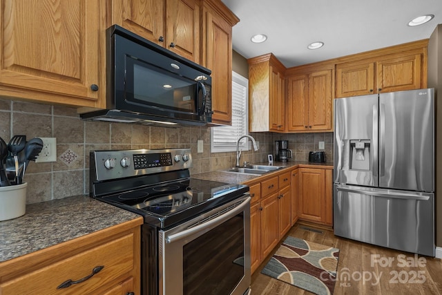 1974 Redwood Dr, Oakboro, NC 28129 - kitchen featuring stainless steel appliances, brown cabinetry, wood finished floors, and recessed lighting