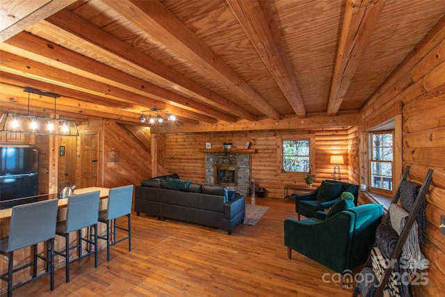 2311 Old Mountain Rd, Mars Hill, NC 28754 - living area with a stone fireplace, light wood finished floors, rustic walls, and a wooden ceiling with exposed beams
