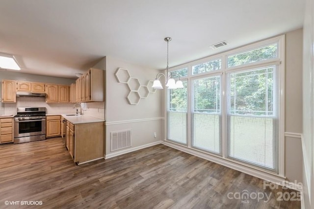 608 Laurel Fork Dr, Matthews, NC 28105 - kitchen with gas range, under cabinet range hood, light brown cabinetry, light countertops, and dark wood finished floors
