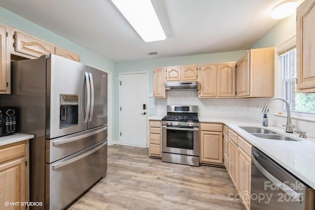 608 Laurel Fork Dr, Matthews, NC 28105 - kitchen with appliances with stainless steel finishes, light brown cabinetry, under cabinet range hood, light countertops, and light wood finished floors