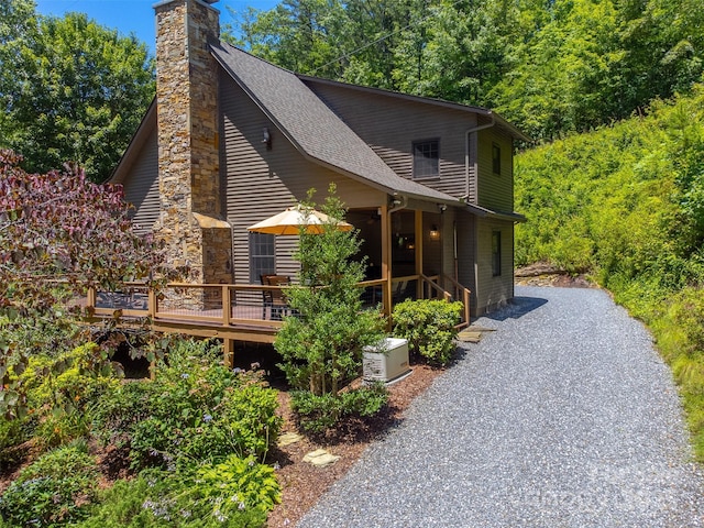 846 Duckback Trl, Whittier, NC 28789 - view of home's exterior featuring a deck, a shingled roof, and a chimney