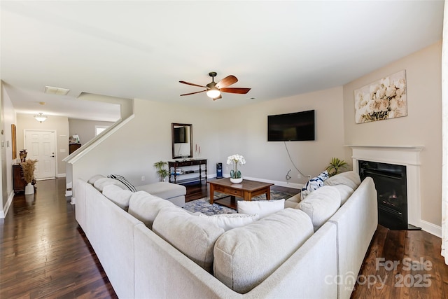 2015 Savannah Hills Dr, Matthews, NC 28105 - living area with dark wood-style floors, ceiling fan, a fireplace with flush hearth, and stairs