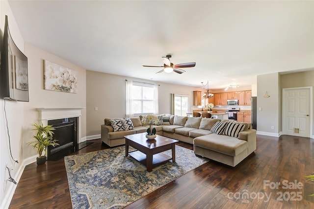 2015 Savannah Hills Dr, Matthews, NC 28105 - living room with ceiling fan, dark wood-style floors, a fireplace with flush hearth, and a chandelier