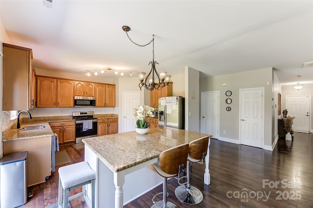 2015 Savannah Hills Dr, Matthews, NC 28105 - kitchen with appliances with stainless steel finishes, a center island, light stone countertops, a breakfast bar, and dark wood-type flooring