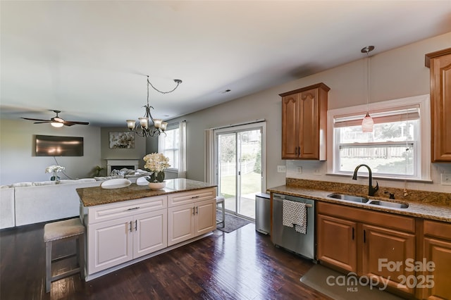 2015 Savannah Hills Dr, Matthews, NC 28105 - kitchen with dishwasher, a fireplace, dark wood-style flooring, open floor plan, and dark stone countertops
