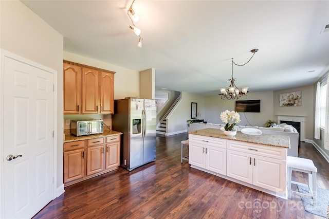 2015 Savannah Hills Dr, Matthews, NC 28105 - kitchen featuring appliances with stainless steel finishes, open floor plan, dark wood-style floors, light stone countertops, and a chandelier