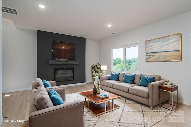837 32nd St NE, Conover, NC 28613 - living room featuring wood finished floors, recessed lighting, and a glass covered fireplace