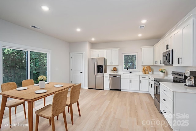 837 32nd St NE, Conover, NC 28613 - kitchen featuring appliances with stainless steel finishes, light countertops, white cabinetry, recessed lighting, and light wood-type flooring