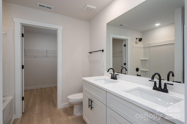 837 32nd St NE, Conover, NC 28613 - bathroom with wood finished floors, a spacious closet, double vanity, a shower, and a tub to relax in