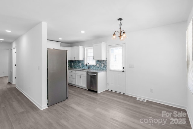 801 Evening Shade Ln, Gastonia, NC 28052 - kitchen with stainless steel appliances, light wood-style flooring, a chandelier, white cabinets, and recessed lighting