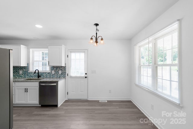 801 Evening Shade Ln, Gastonia, NC 28052 - kitchen with appliances with stainless steel finishes, white cabinetry, a chandelier, backsplash, and light wood-style flooring