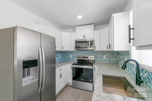 801 Evening Shade Ln, Gastonia, NC 28052 - kitchen with stainless steel appliances, light stone countertops, white cabinets, backsplash, and recessed lighting