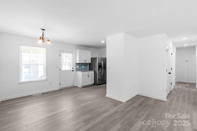 803 Evening Shade Ln, Gastonia, NC 28052 - unfurnished living room with light wood-style flooring, a chandelier, and recessed lighting