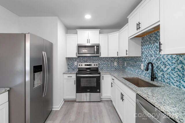 803 Evening Shade Ln, Gastonia, NC 28052 - kitchen featuring stainless steel appliances, light wood-style floors, white cabinetry, backsplash, and recessed lighting