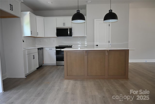185 Cherry Springs Ln Unit 24-C, Asheville, NC 28804 - kitchen featuring stainless steel appliances, a kitchen island, backsplash, light wood finished floors, and white cabinetry