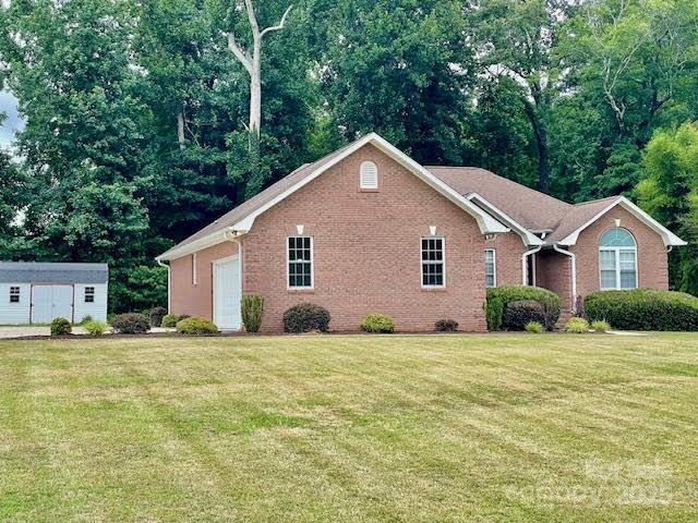 205 Hidden Spring Dr, Salisbury, NC 28147 - view of side of property with a lawn, brick siding, and a storage shed