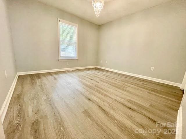 205 Hidden Spring Dr, Salisbury, NC 28147 - empty room featuring wood finished floors and a chandelier
