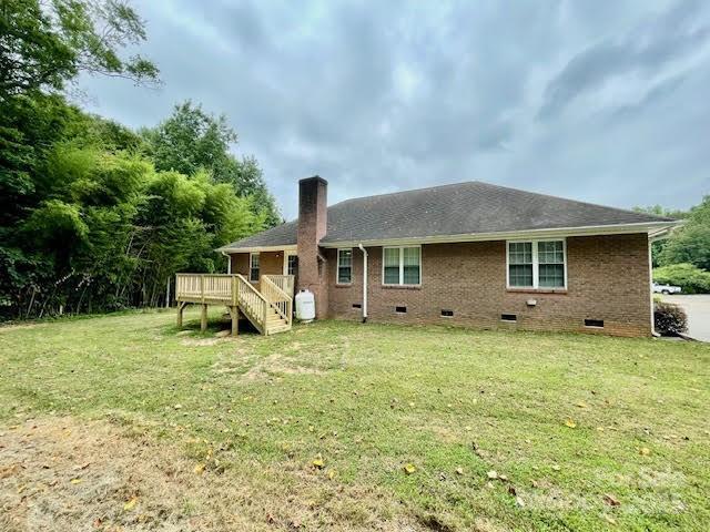 205 Hidden Spring Dr, Salisbury, NC 28147 - rear view of house with crawl space, a chimney, a wooden deck, a yard, and brick siding