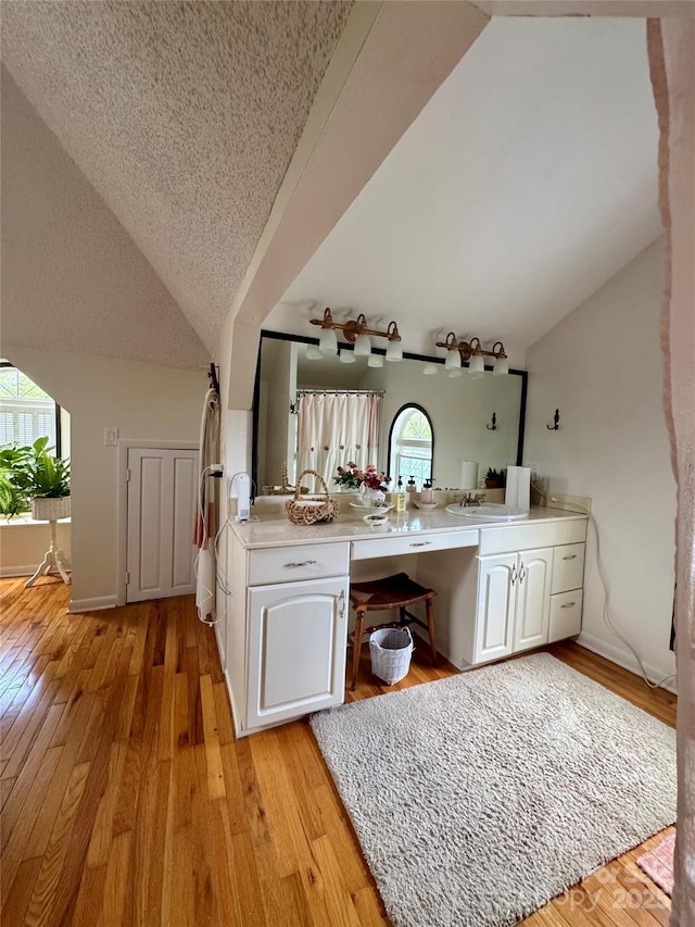 227 Reep Dr, Morganton, NC 28655 - bathroom with lofted ceiling, double vanity, wood-type flooring, a textured ceiling, and a shower with curtain