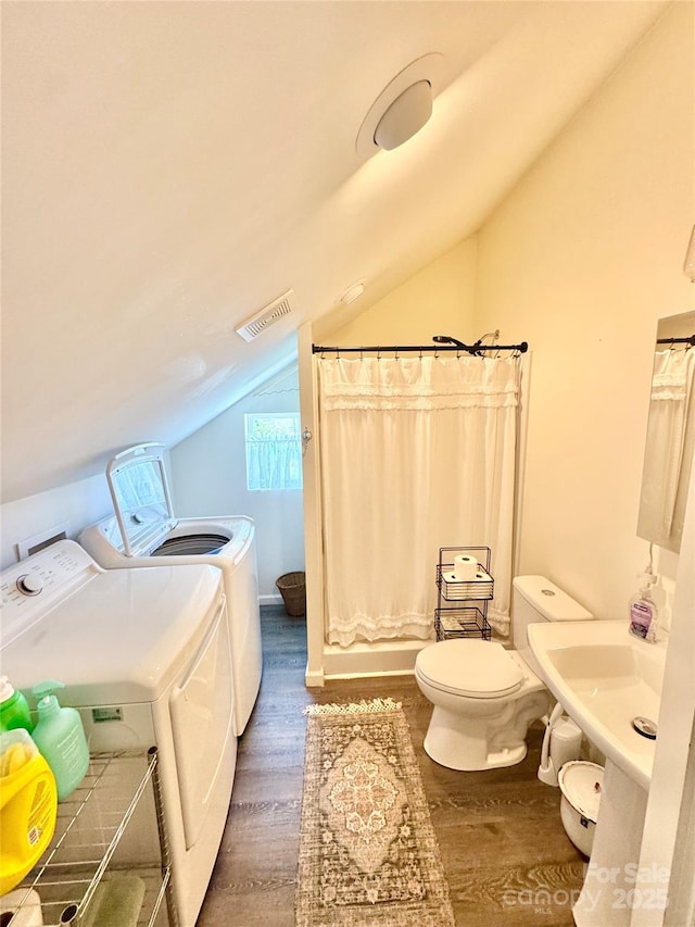227 Reep Dr, Morganton, NC 28655 - bathroom featuring washer and clothes dryer, vaulted ceiling, wood finished floors, and a shower with curtain