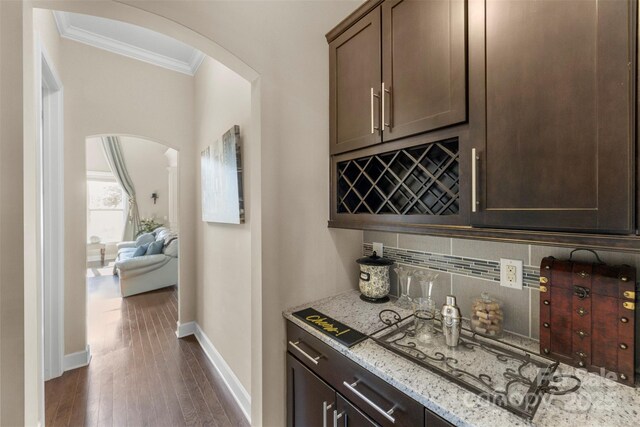 1204 Vaugelas Ct, Monroe, NC 28110 - indoor dry bar with ornamental molding, arched walkways, decorative backsplash, and dark wood-style flooring