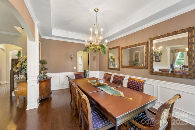 1204 Vaugelas Ct, Monroe, NC 28110 - dining room featuring arched walkways, a tray ceiling, dark wood-style flooring, a chandelier, and a decorative wall