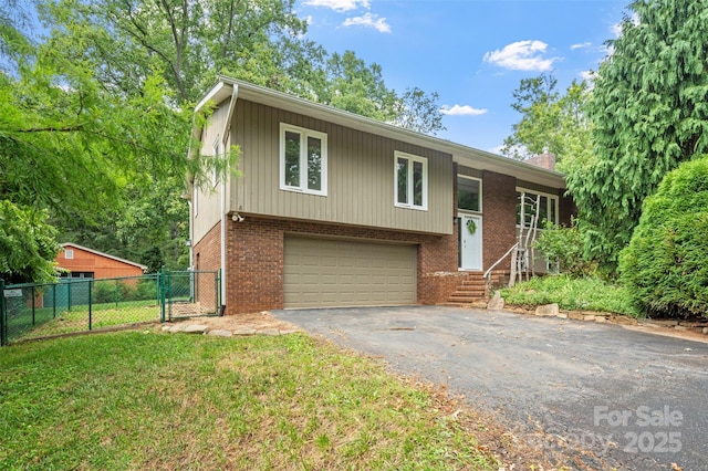 15 Beaverdam Ct, Asheville, NC 28804 - split foyer home featuring asphalt driveway, an attached garage, brick siding, and a chimney