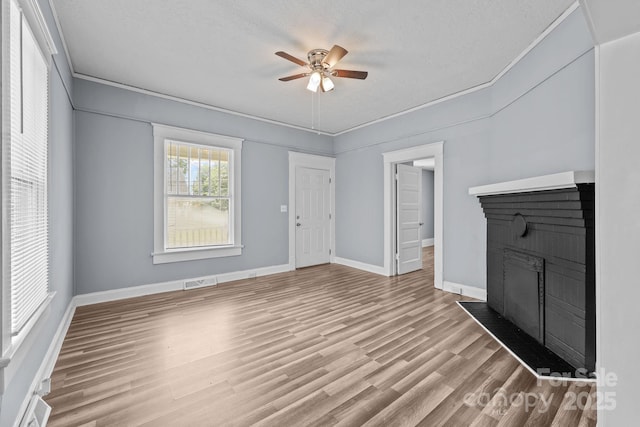 200 N Martin Luther King Jr Ave, Salisbury, NC 28144 - unfurnished living room featuring a fireplace, a ceiling fan, wood finished floors, crown molding, and a textured ceiling