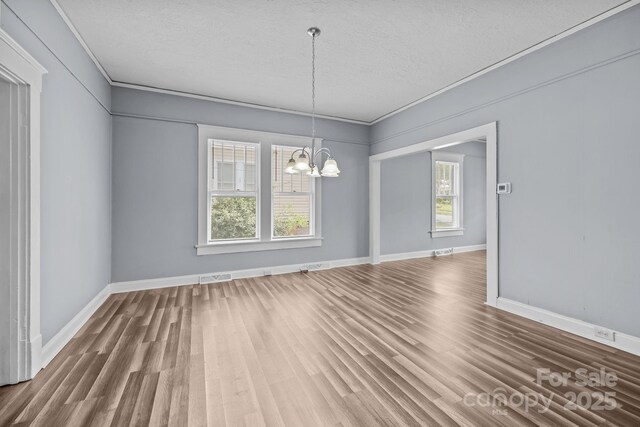 200 N Martin Luther King Jr Ave, Salisbury, NC 28144 - unfurnished dining area featuring a chandelier, wood finished floors, a textured ceiling, and ornamental molding