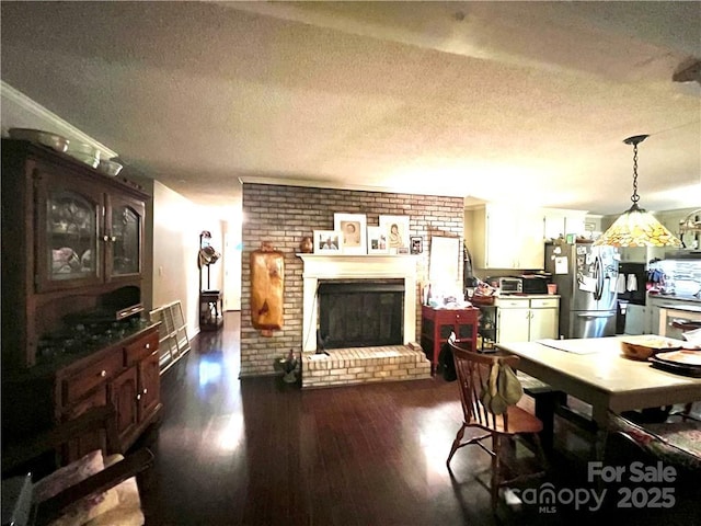 5419 Stevens Mill Rd, Matthews, NC 28104 - dining room with a textured ceiling, dark wood-style floors, a brick fireplace, and brick wall