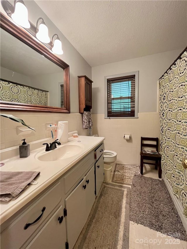 5419 Stevens Mill Rd, Matthews, NC 28104 - bathroom with tile walls, vanity, wainscoting, a textured ceiling, and curtained shower