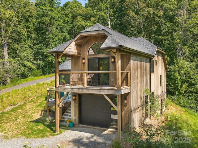 184 Sandys Home Pl, Mars Hill, NC 28754 - view of front facade with a shingled roof, an attached garage, a forest view, gravel driveway, and stairway