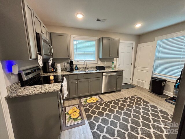 408 E 22nd St, Kannapolis, NC 28083 - kitchen featuring stainless steel appliances, light wood finished floors, gray cabinetry, light stone countertops, and recessed lighting