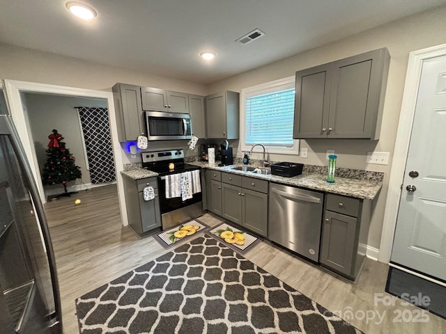 408 E 22nd St, Kannapolis, NC 28083 - kitchen with stainless steel appliances, gray cabinets, light wood-style flooring, light stone countertops, and recessed lighting