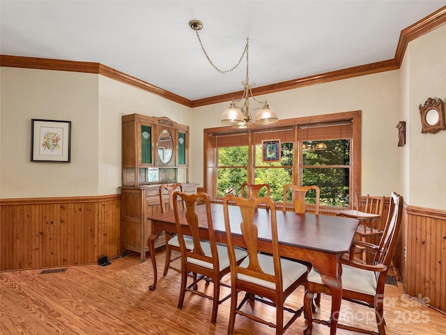 599 Red Fox Ln, Flat Rock, NC 28731 - dining area featuring wainscoting, light wood-type flooring, ornamental molding, wooden walls, and a chandelier